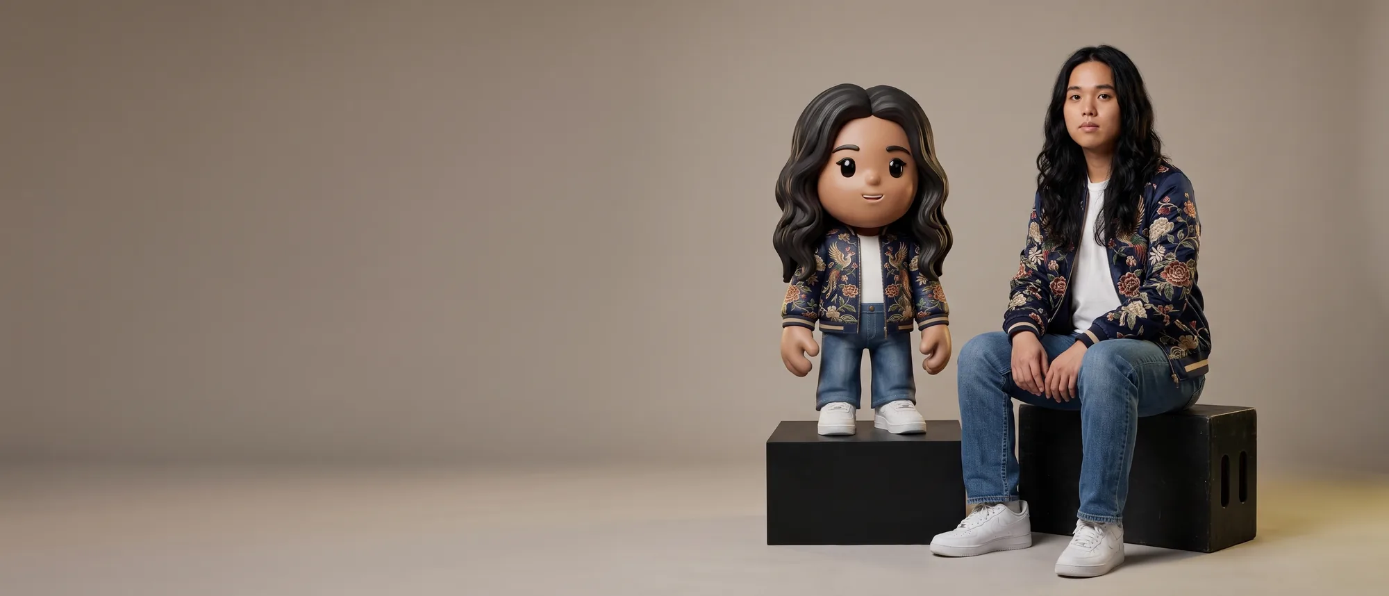 A person seated beside the 24-inch MEYO figure of themselves, standing on a plinth at their eye level